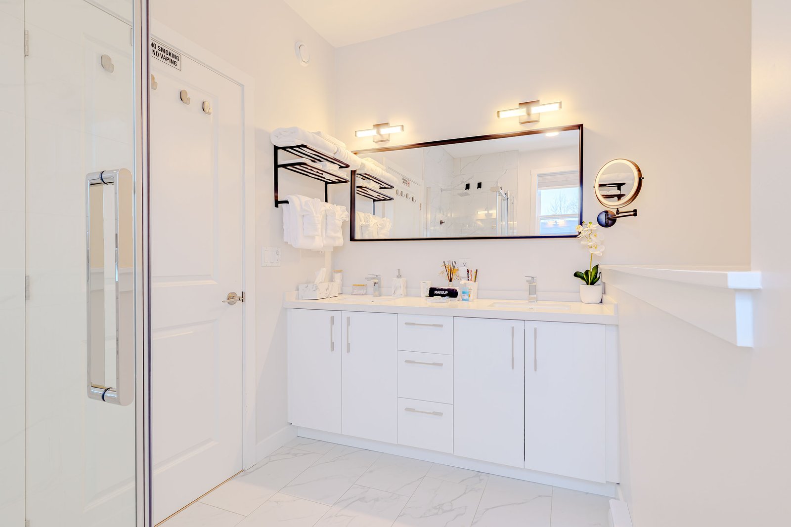 Double sink vanity with black towel rack and folded white towels at Starz at Night luxury suite