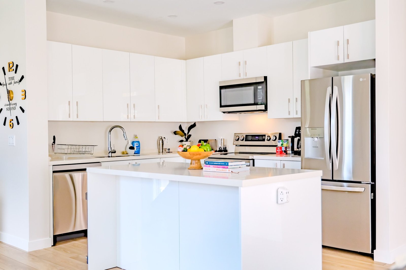 Bright white kitchen with island, stainless steel fridge, microwave, and stove at Starz at Night luxury suite