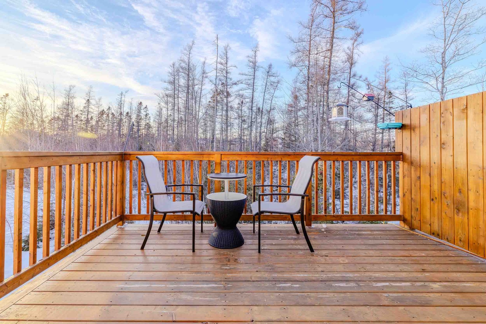 Private wooden deck with seating and cozy table overlooking a scenic forest view at Starz at Night Luxury Suite